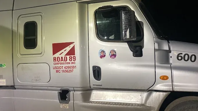 White semi-truck cab with “Road 85” logo and the number 600 on the door, parked at night.